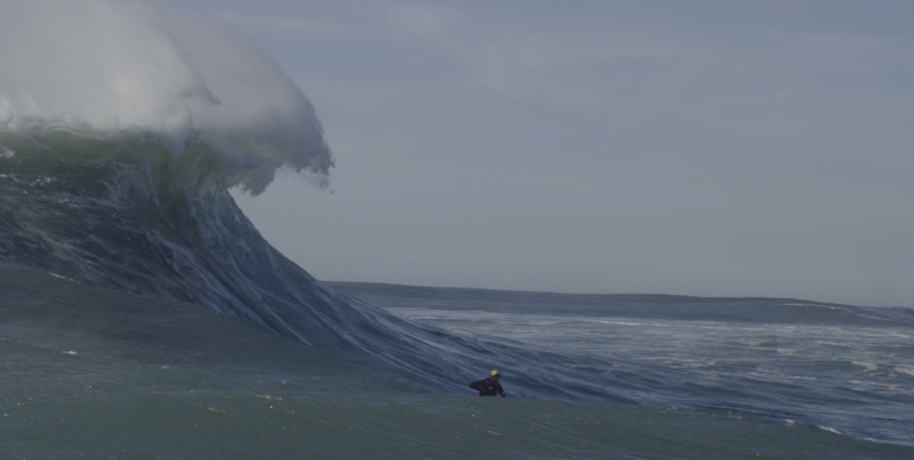 Nazaré – winziger Surfer vor der Monsterwelle (Filmstill)